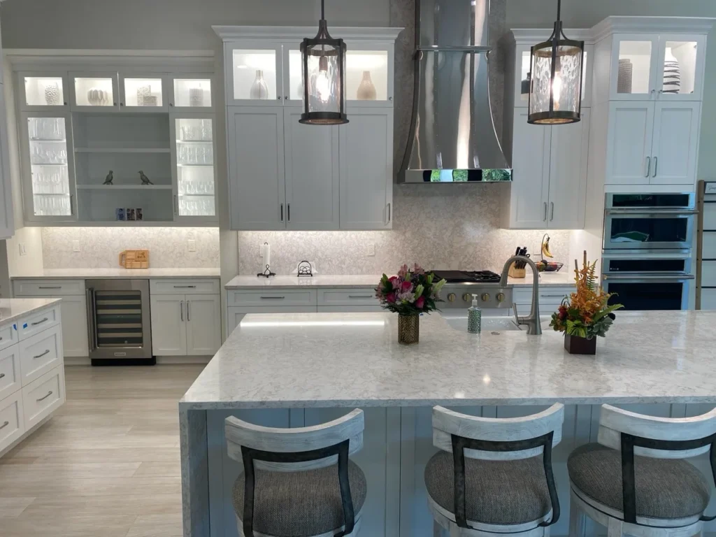 White kitchen with illuminated glass cabinets, a large island and integrated appliances