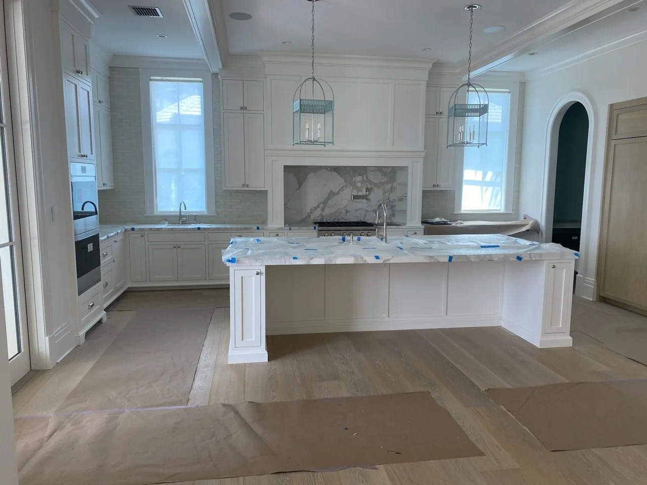 White manufactured kitchen cabinetry with a large paneled island
