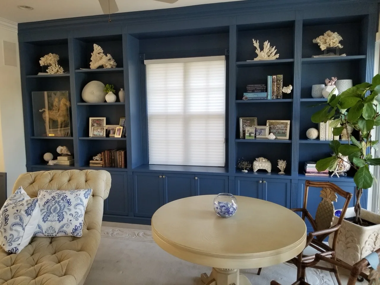 Floor-to-ceiling navy built-in library with display shelving and closed storage
