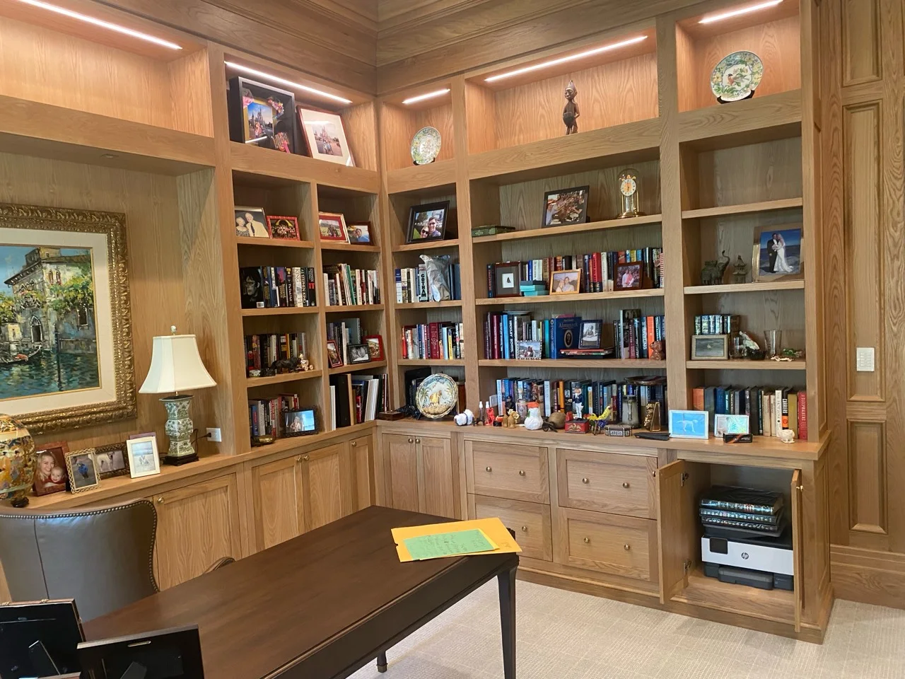 Wraparound oak home office library with integrated lighting, shelving and storage