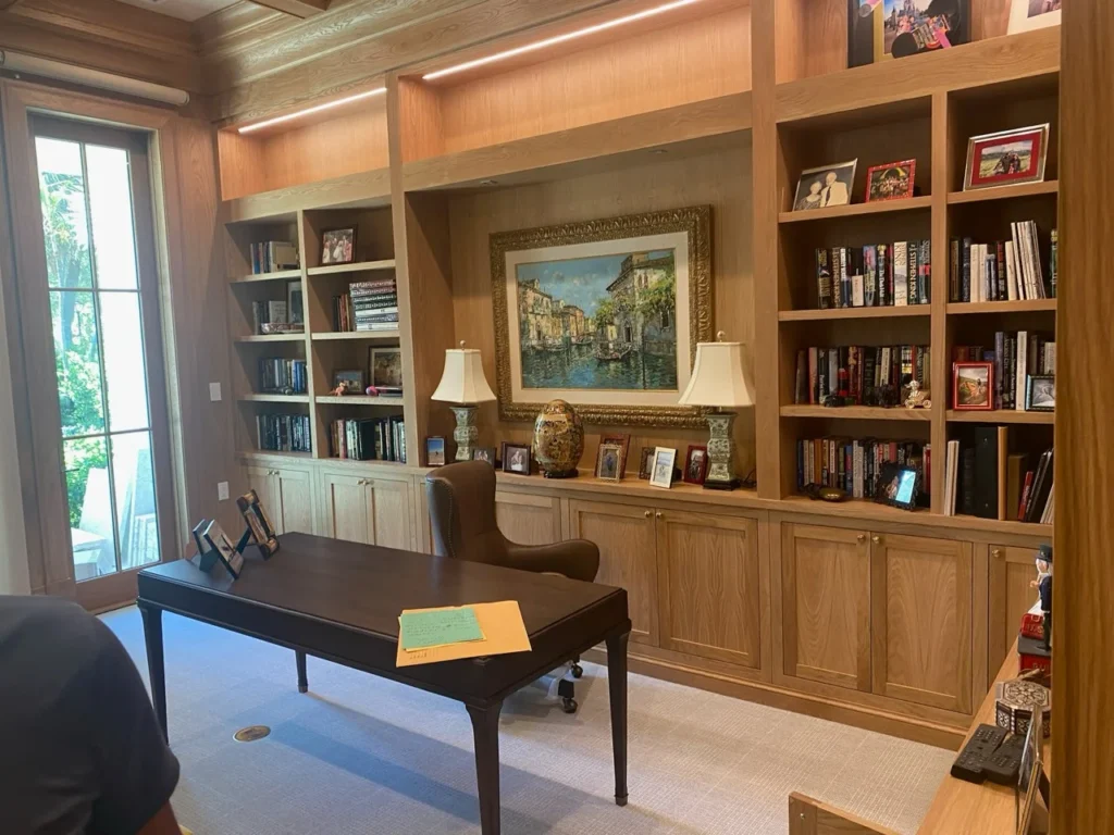 Oak home office with full-height bookcases, display lighting and concealed storage