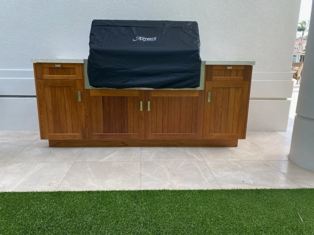 Outdoor teak barbecue cabinet built around an Alfresco grill with drawers and door storage