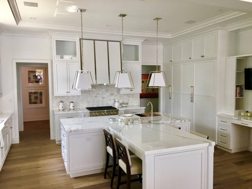 White kitchen featuring a custom range hood fabricated by JR Custom Cabinetry