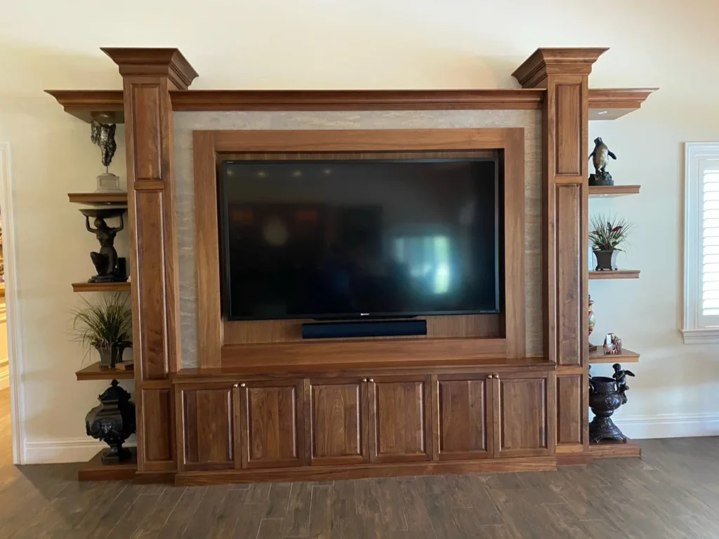Walnut media wall with integrated television, architectural columns and display shelves